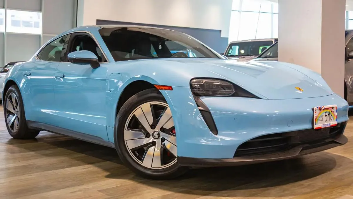 A 2021 Porsche Taycan 4S in light blue, photographed from the front three-quarter angle, one of the 63 cars in the Island Luxe fleet on Oʻahu.
